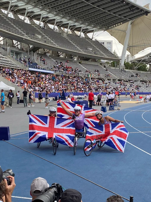 Hannah Cockroft, Kare Adenegan and Fabienne André pose with British flags after winning gold, silver and bronze in the women's T34 100m.