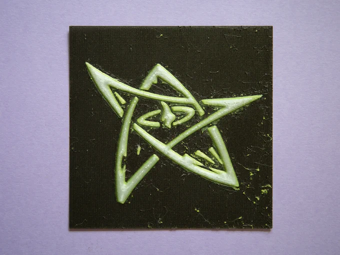 A 3D printed Elder Sign from the Cthulhu Mythos, in 3 visible colors: glittery-gold black background, vibrant lime green and soft white.