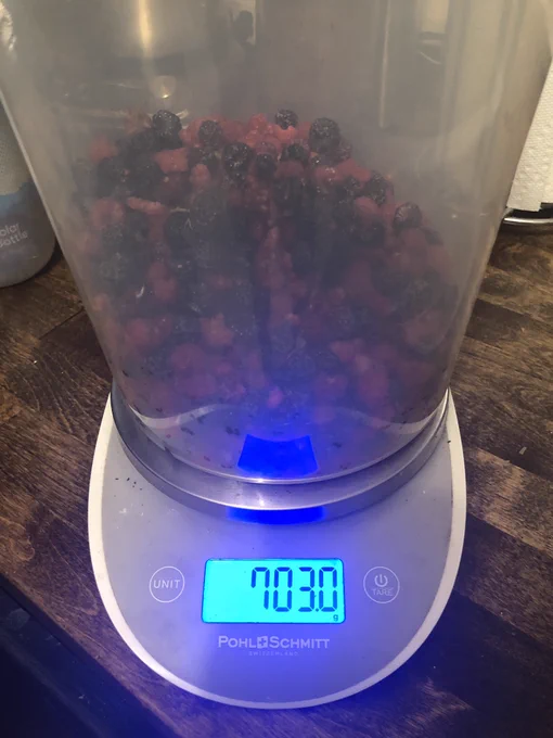 Bucket of raspberries on a scale measure 703 grams