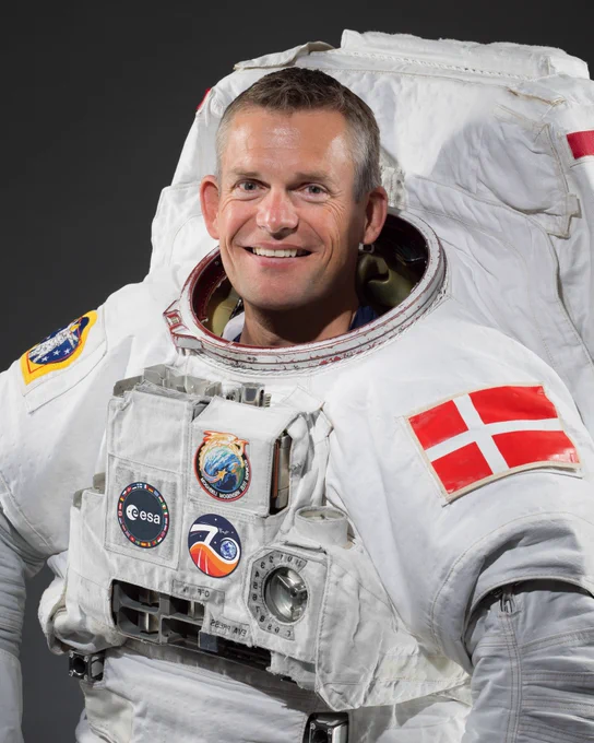 ESA astronaut Andreas Mogensen in the Extravehicular Mobility Unit (EMU) suit with the Danish flag on his left arm. On his chest is the Crew-7 patch, the ESA logo and Expedition 70 patch. 