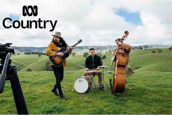 Pictured: Mark Curtis & The Flanelettes captured playing their instruments atop a rolling green hill.  