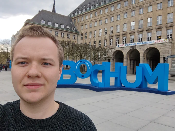 Thomas standing in front of Bochum Town Hall and big blue wooden letters spelling Bochum