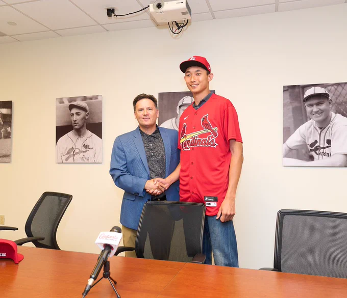 Chen-Wei Lin shakes hands with St. Louis Cardinals executive Matt Slater after signing his contract with the team