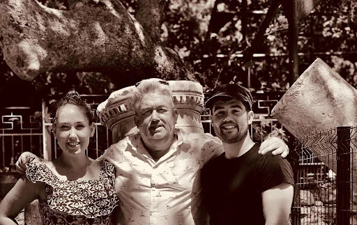 Professor Joe McDonald and family underneath the tree where medicine was first taught by Hippocrates on the Greek island of Kos more than 2,500 years ago.