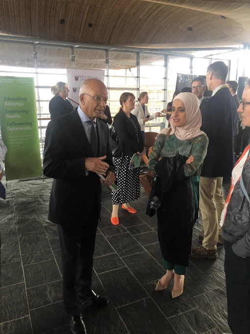 Asmaa Al-allak speaks to event attendees in a foyer