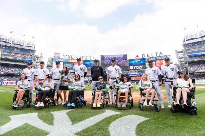 Sarah Langs, alongside other women living with ALS, take the field with Yankees players and personnel as they are honored during Yankees HOPE Week.