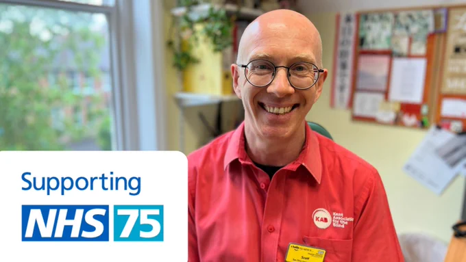 Scott, our ECLO, smiling to camera, inside his office. Supporting NHS 75 logo appears bottom left.