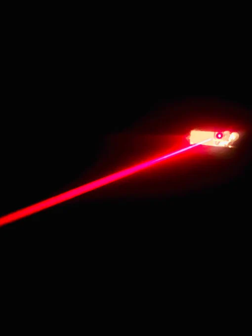 Ein roter Laserstrahl schießt aus der Wand im ersten ERS-EscapeRoom. Alles andere schwarz.