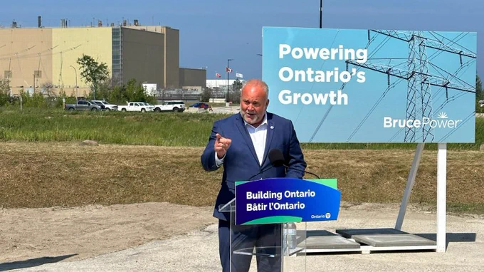 Minister Todd Smith on Bruce Power's site speaking in front of a podium.
