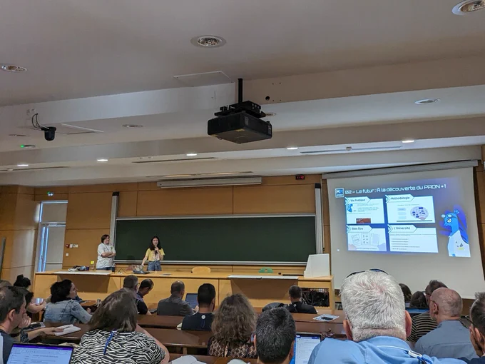 Deux ingénieures pédagogiques du Learning Lab UO sur l'estrade d'un amphi et un powerpoint montrant les catégories du PAON