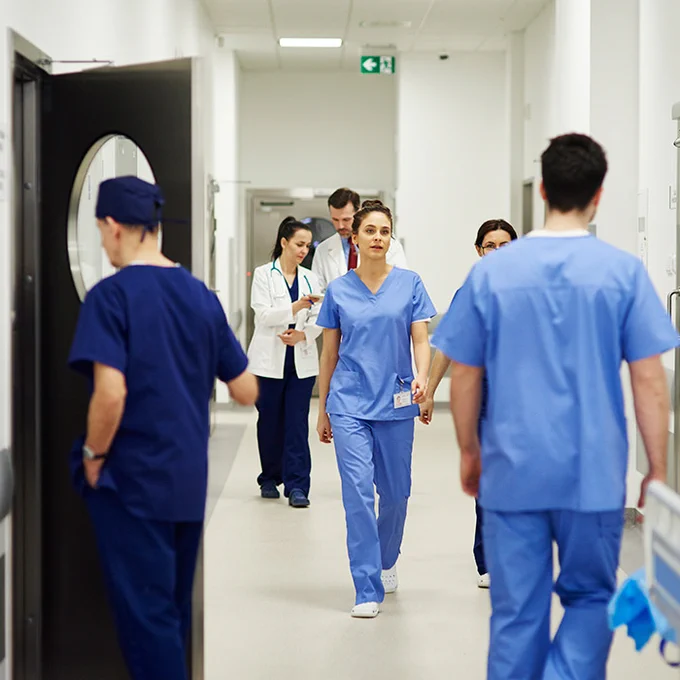 Medical staff walking through a hospital hallway.