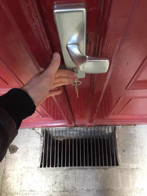 A door with a grate underneath.  A person hangs their keys precariously above it.