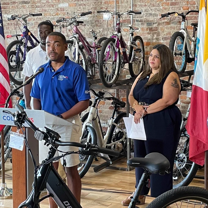 A photo of Council President Shannon Hardin and Councilmember Lourdes Barroso de Padilla announcing an e-bike incentive pilot program at a bike shop.