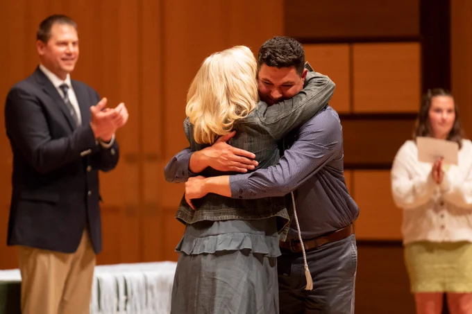a student hugs a professor