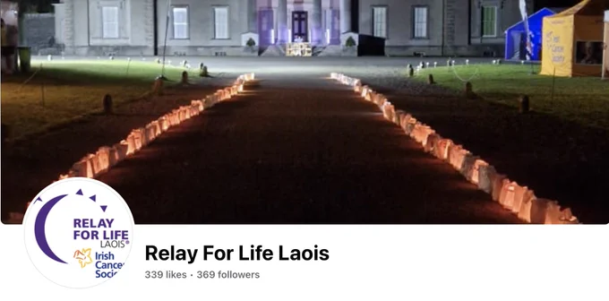 A screen grab of the Relay for Life Laois Facebook page showing two rows of lit candlebags leading up to the front entrance to Emo House, Co. Laois. The picture is taken at night time and the candlebags illuminate the walking path for the Relay for Life.