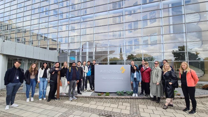AIDD fellows including several PIs in front of the main entrance to the company in Mölndal, Sweden.