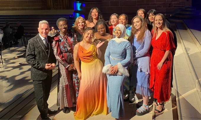 Honorary Fellow Gary Millar and Chancellor Nisha Katona look at the camera with 11 JMSU officers past and present in Liverpool's Anglican Cathedral