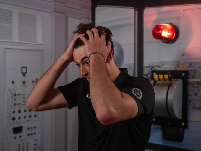 Logan Neaton runs his fingers through his hair while trying to solve a puzzle at Enigma Escapes