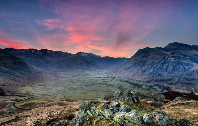 photo of the Langdales with a pink sky and dry stone walling at the forefront 