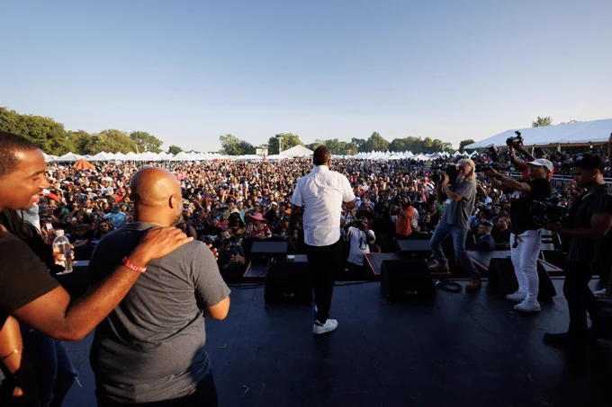Photo ID: Mayor Johnson stands on stage in front of a large crowd.