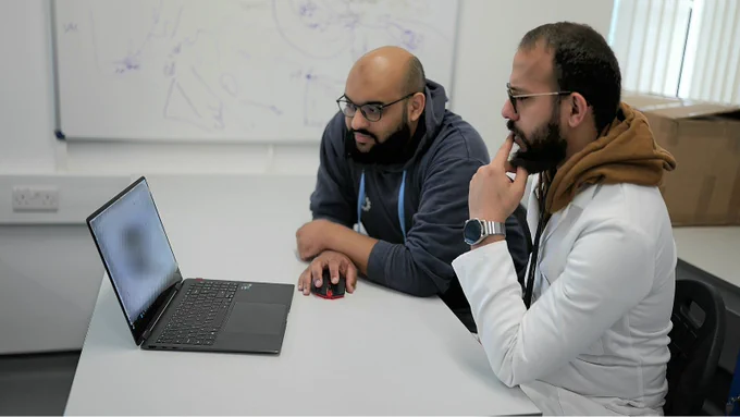 Co-Founders of NovNat, Ibrahim Albaik and Abdulbari Belouafi, sitting at a desk and looking at a laptop. Credit: NovNat