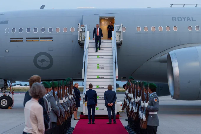Australian Prime Minister Anthony Albanese exits a plane. He is welcomed by Ambassador Philip Green and others.