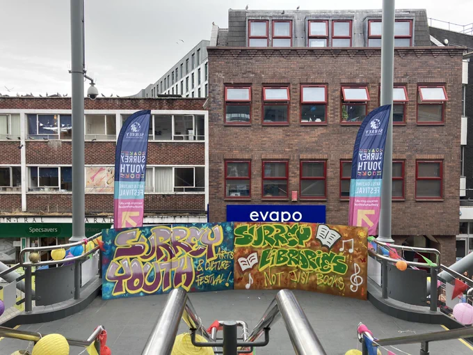 Two graffiti art pieces. One in blue and purple saying ‘Surrey Libraries Youth and Culture Festival’ and a green and yellow one saying ‘Surrey Libraries - Not Just Books’.