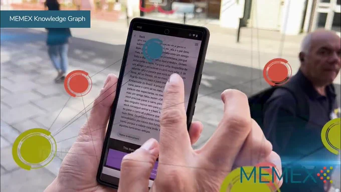 Picture of someone holding a phone, on the phone we can see the MEMEX Knowledge Graph