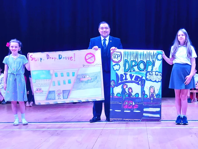 Councillor Chan presenting the winning banners on the last day of school 