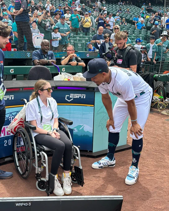 Sarah Langs and Julio Rodríguez have a chat on the on field during batting practice. 