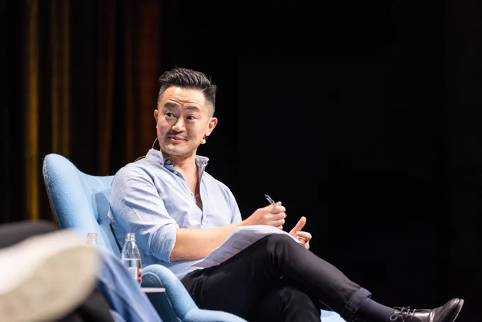 Benjamin Law, eyes wide in a surprised expression, on stage during Great Adaptations at Sydney Writers' Festival 2023.