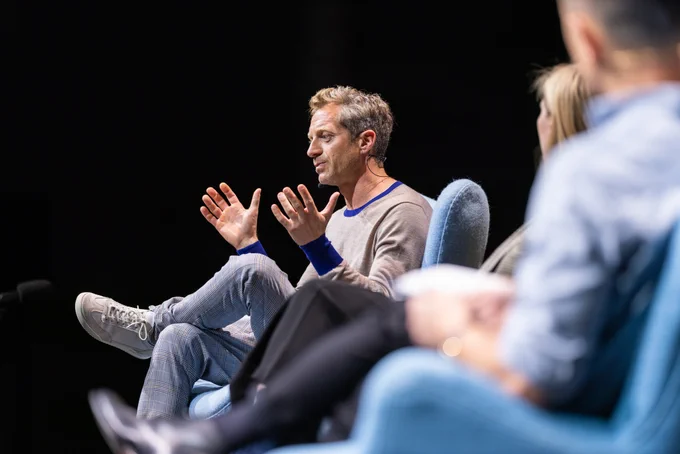 Tom Rob Smith on stage at Sydney Writers' Festival 2023, arms wide in expression.
