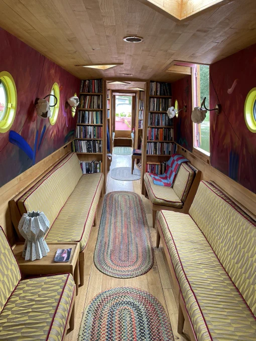 interior of canal barge with seating and book shelves