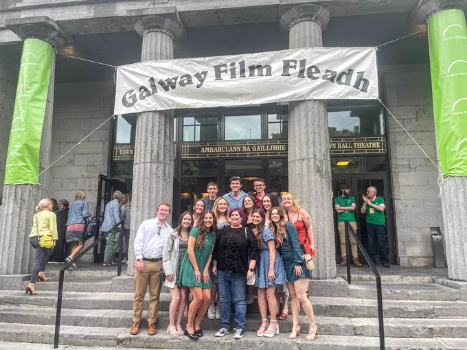 Crowd of people posing in front of the Town Hall Theatre under a Galway Film Fleadh banner 