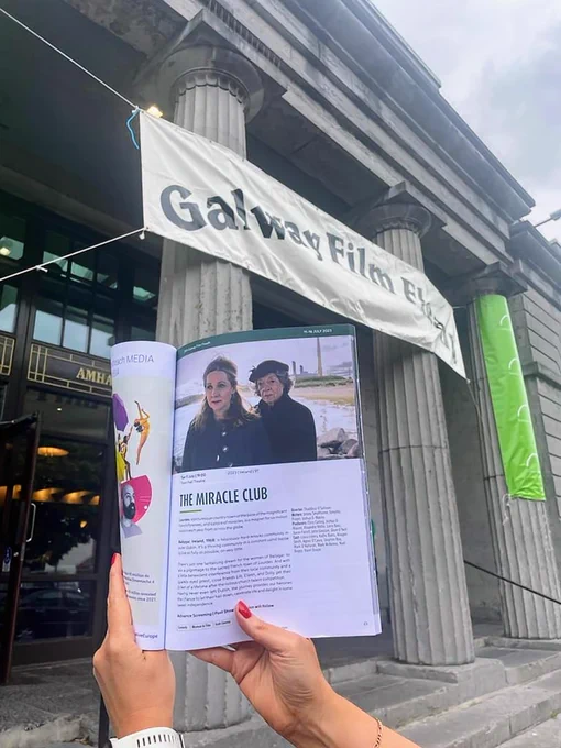 Galway Film Fleadh programme open on the page of 'The Miracle Club' held underneath a Film Fleadh banner at the Town Hall Theatre