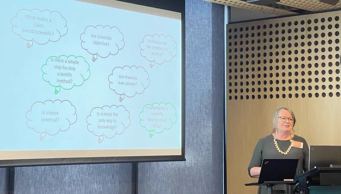 Robyn Yucel with a slide that has questions in thought bubbles