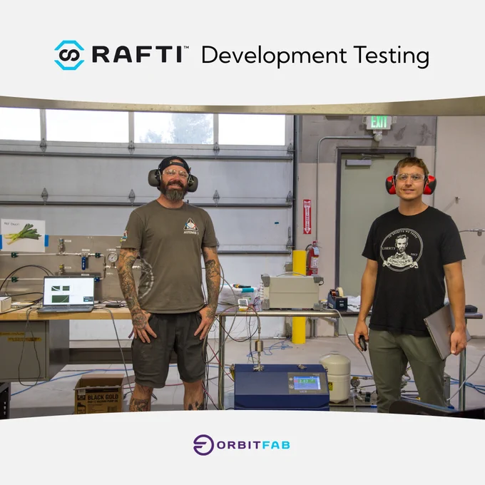 Picture of Dave and Diarmuid wearing safety gear, standing in front of testing equipment. perform a leak check