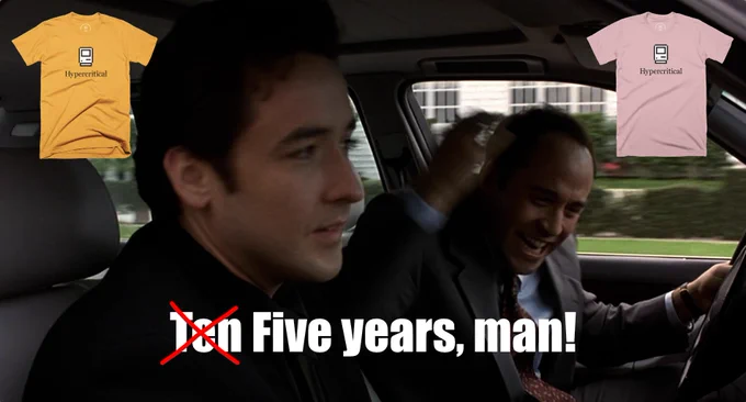 The scene in Grosse Pointe Blank where John Cusack and Jeremy Piven are in a car, and Piven can’t believe Cusack has been gone for “Ten years, man!” In the subtitle text, the word “Ten” is crossed out with a red “X” and “Five” is written in its place. A gold Hypercritical t-shirt and a pink Hypercritical t-shirt appear in the upper left and right corners of the frame.
