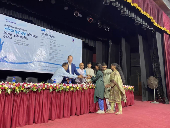 The winner team of College level-Government Science College, Dhaka is receiving trophy, certificates and books from the guests.