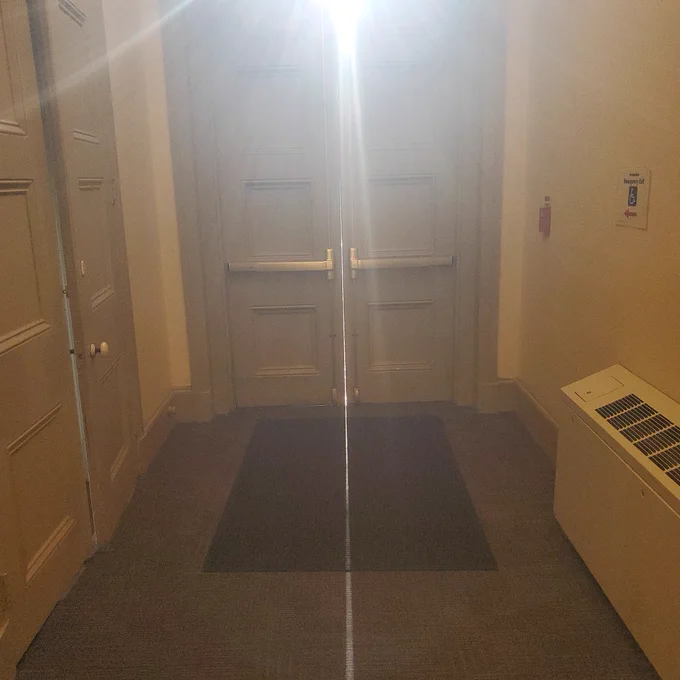 The same double doors again. The camera is angled higher this time. The sun's rays are smeared out across the top of the image.