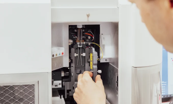 A close-up of the flow chamber of an ICS machine, with a scientist’s hand in the foreground.