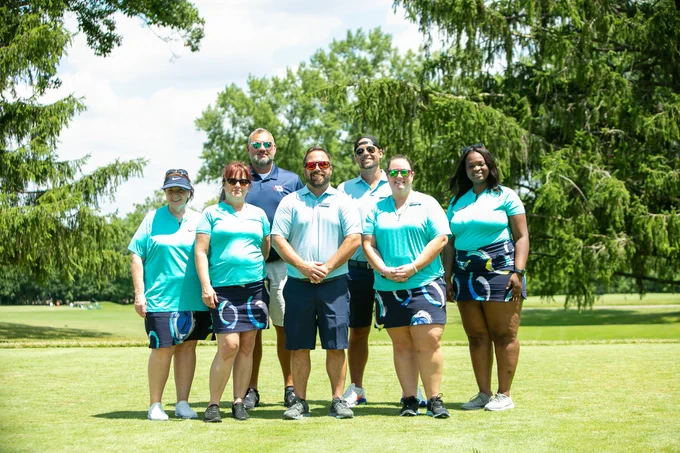 A group of golfers pose for the camera.