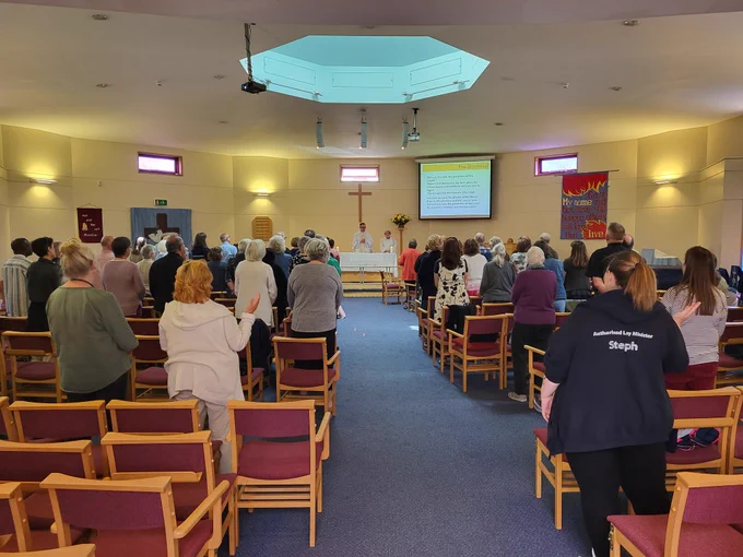 100 people stood in church facing the alter. 