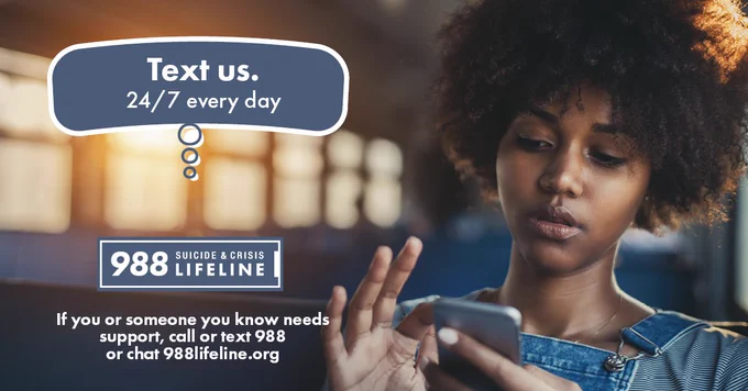 Graphic with a photo of a young Black woman seated alone on an empty bus texting on her smartphone, with text “Text us 24/7 every day. 988 Suicide & Crisis Lifeline. If you or someone you know needs support now, call or text 988 or chat 988Lifeline.org.”