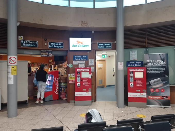 A photo of the interior of Waterford bus station. There are counters and ticket machines for Bus Eireann.