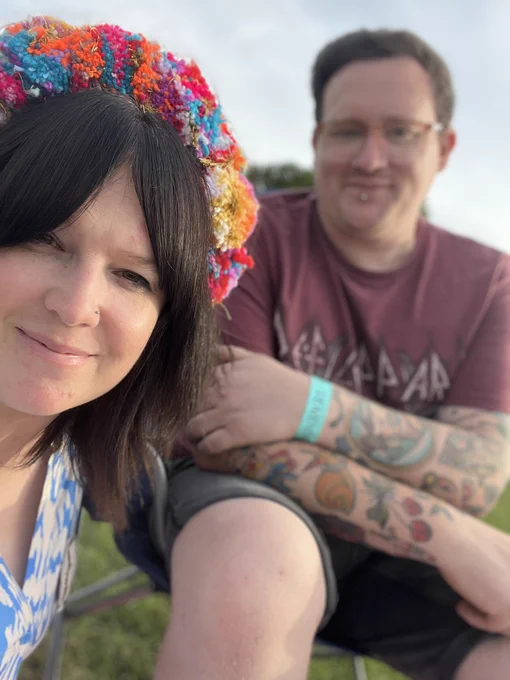 Me and Gem relaxing after the craft weekend. I’m wearing a Def Leppard T-shirt and you can see my tattooed arms and vendor wristband. Gem is wearing a blue dress and a fabulous Pompom headband.