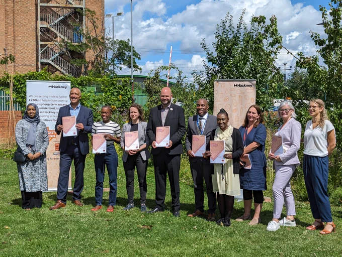 Council leaders, food justice partners holding commission report for photo