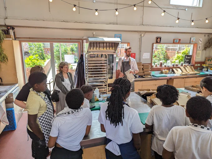 Schoolchildren gathering round Hackney School of Food kitchen in Mandeville Primary School