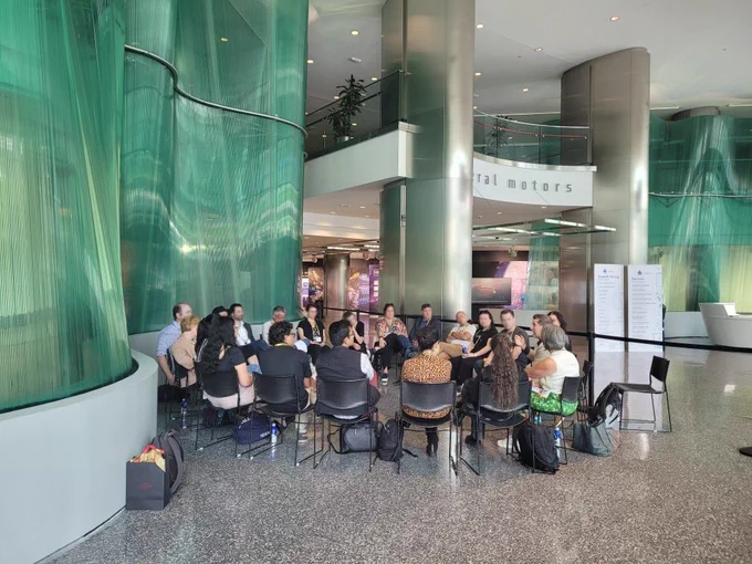A group of people sit in a circle having a discussion.