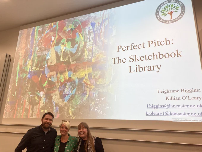 Image shows Leanne from Beaumont College posing with Leighanne and Killian in front of their pitch perfect slides following their success in securing funding for their Sketchbook Library project.